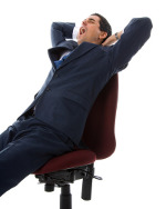 Ein Geschäftsmann sitzt in seinem Büro Sessel und fühlt sich dabei müde und schlapp